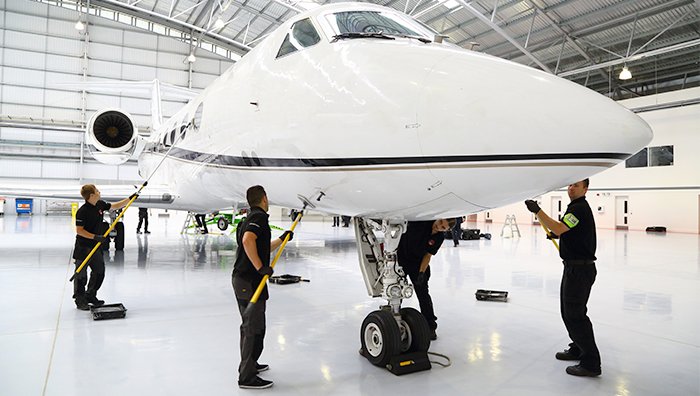 GCS team detailing aircraft exterior in hangar Bay Area