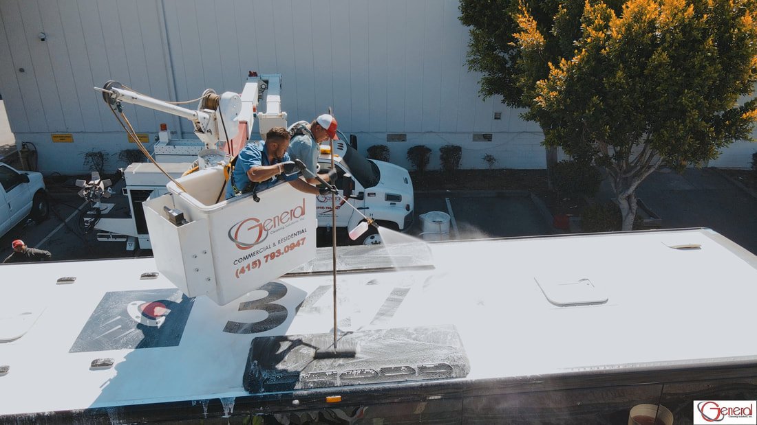 GCS team washing top of bus from cherry picker